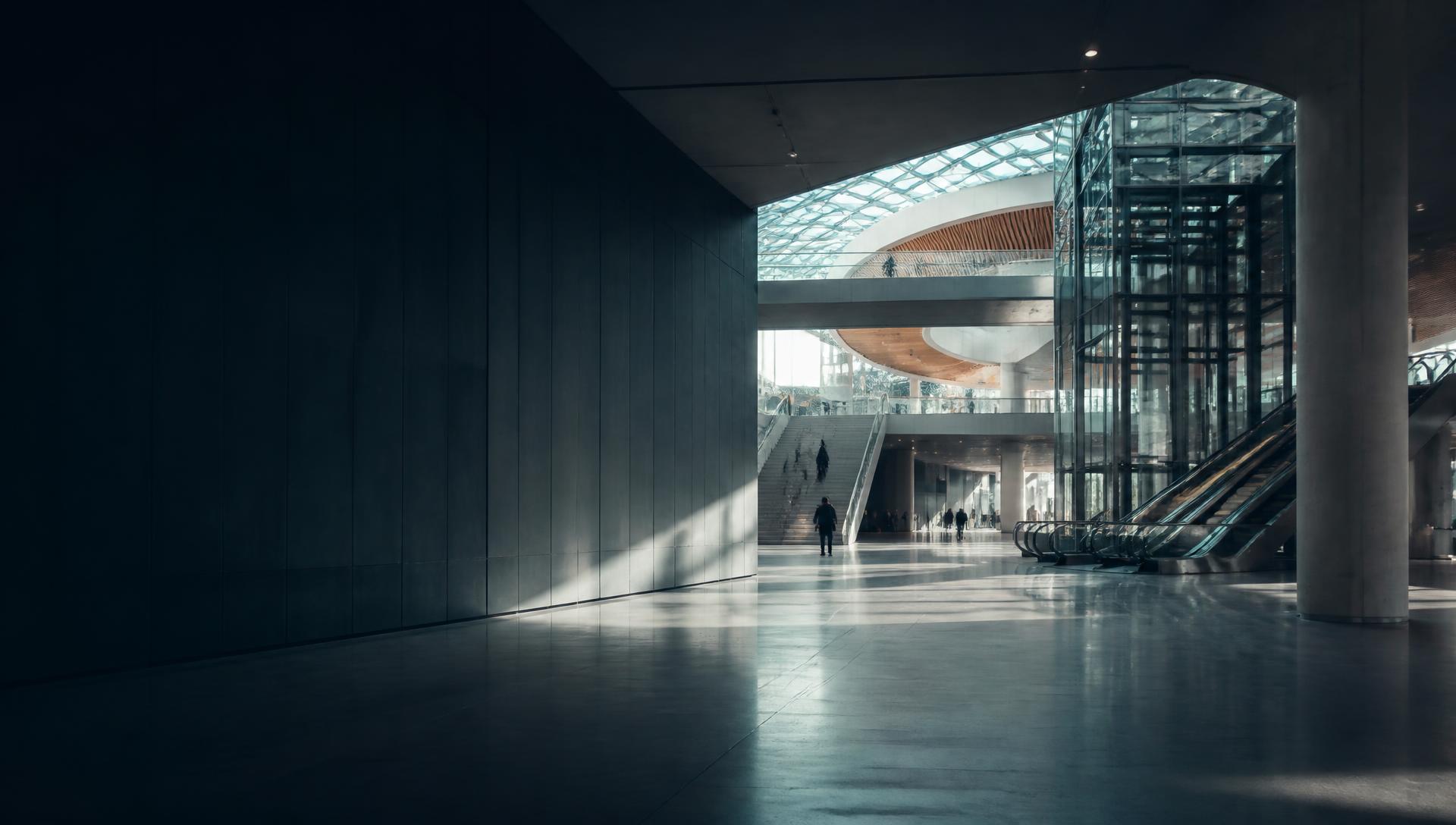 A spacious contemporary public atrium with lifts, escalators and open concourses